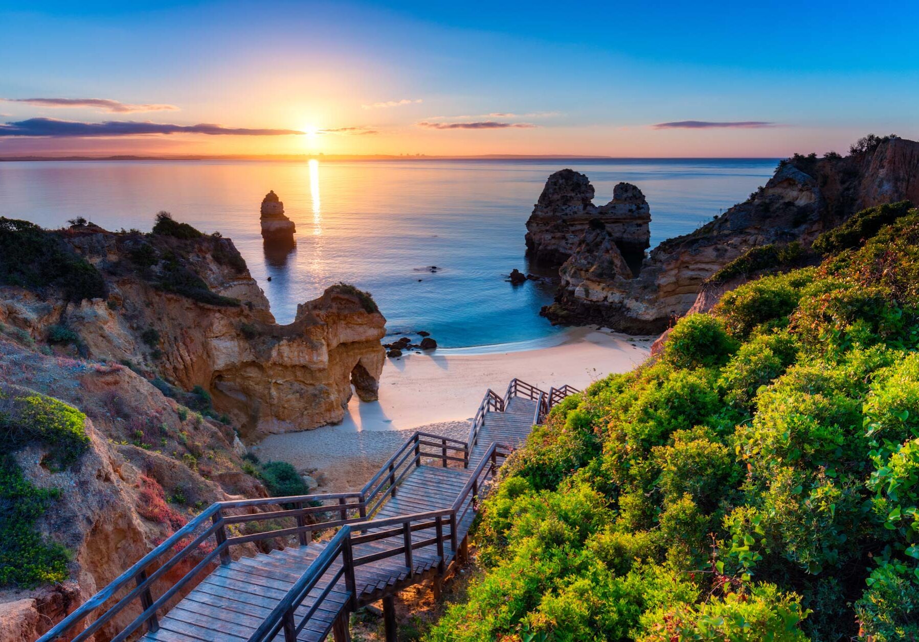 Camilo Beach (Praia do Camilo) at Algarve, Portugal with turquoise sea in background. Wooden footbridge to beach Praia do Camilo, Portugal. Wonderful view of Camilo Beach in Lagos, Algarve, Portugal.