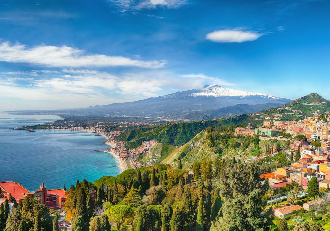 Aquamarine blue waters of  sea near Taormina resorts and Etna volcano mount. Giardini-Naxos bay, Ionian sea coast, Taormina, Sicily, Italy.