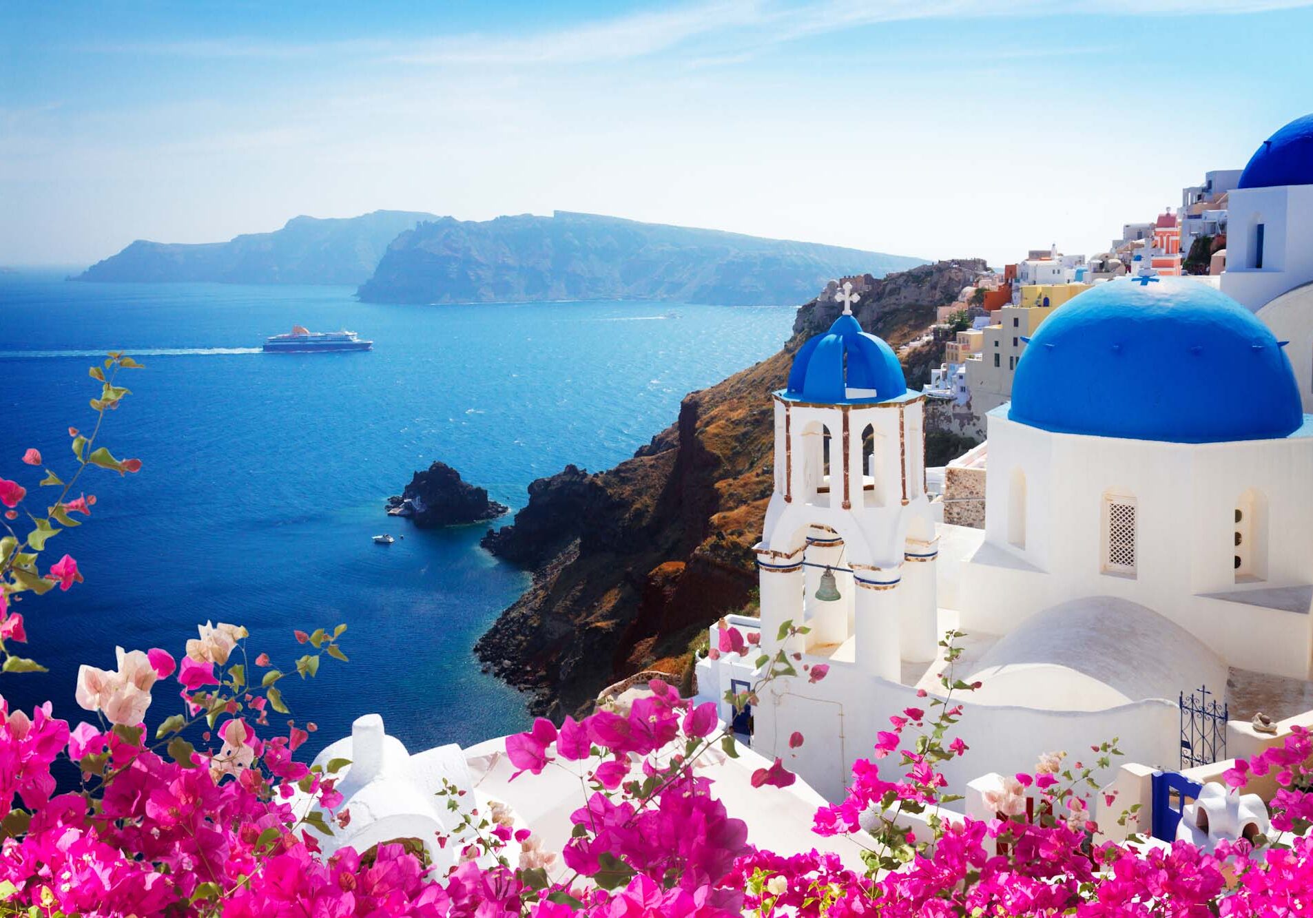 volcano caldera with blue church domes, Oia with flowers, Santorini, toned